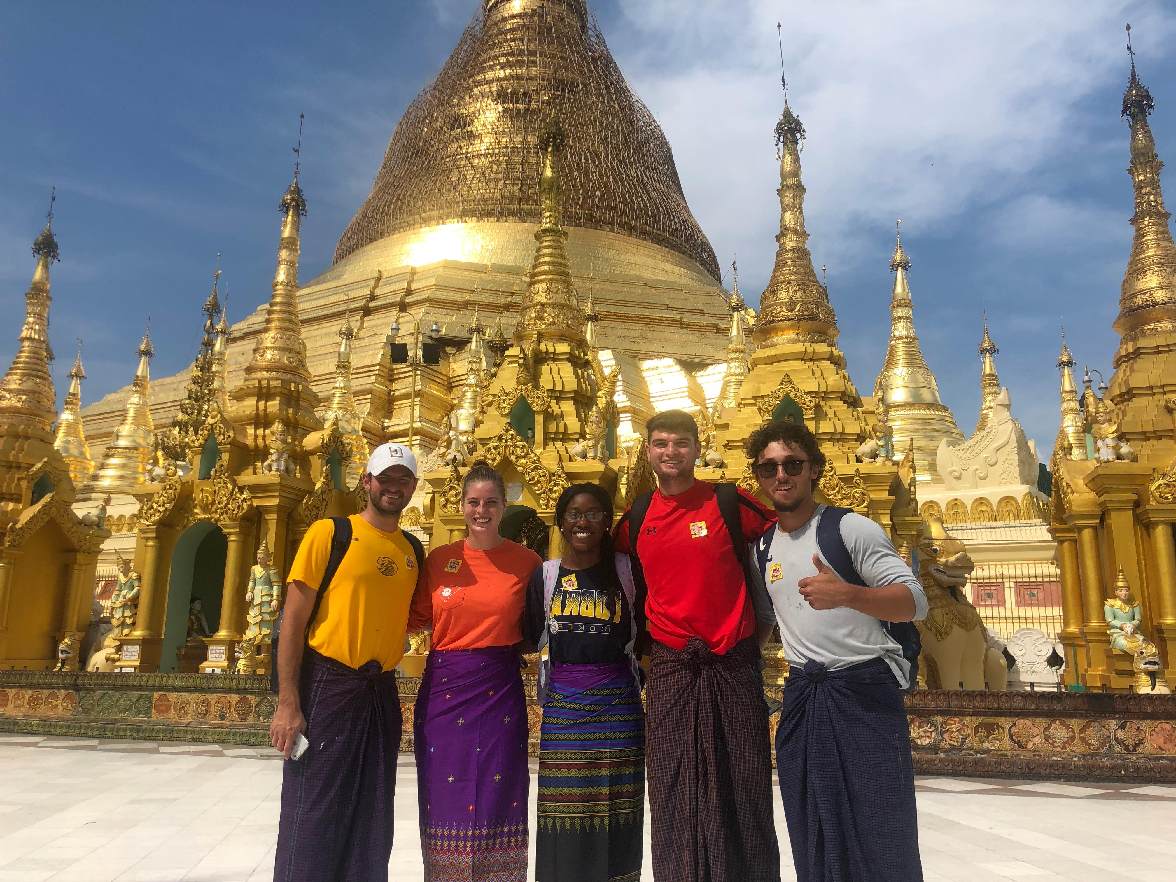 一群五名学生在缅甸的一座寺庙前摆姿势
